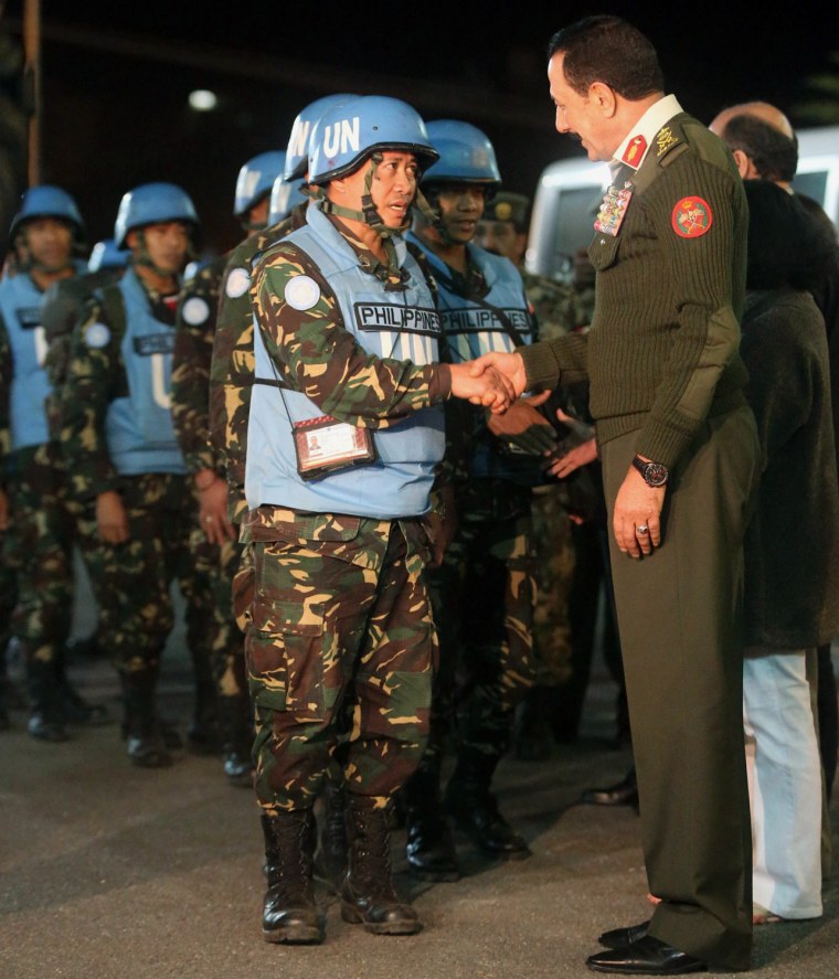 Chief of Staff Mishaal al Zaben greets the 21 Filipino UN peacekeepers who were held hostage as they arrive in Amman after crossing into Jordan from Syria on Saturday.