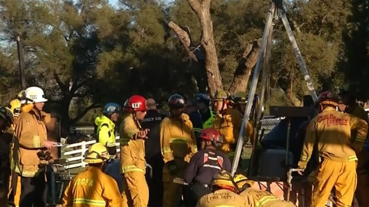 Rescue crews lower a firefighter into a well in Portrero, Calif., to rescue a man who had fallen inside.