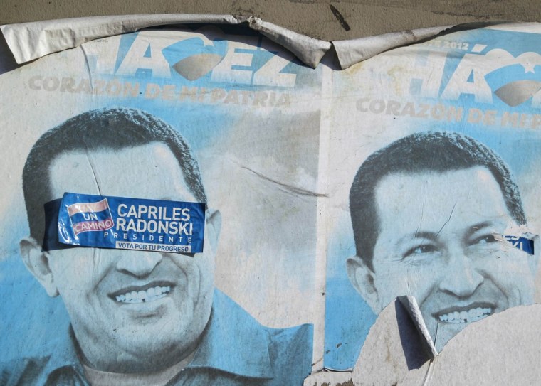 A sticker bearing the name of Venezuela's opposition leader Henrique Capriles is seen stuck on a poster of the late President Hugo Chavez outside of the Military Academy, where the funeral service of Chavez is being held, in Caracas, on March 10.