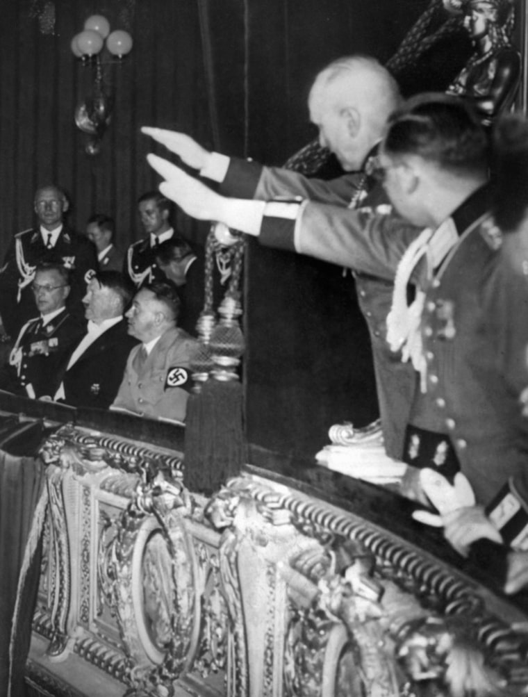German Nazi Chancellor Adolf Hitler sits between his close collaborator Martin Bormann (right) and future Governor of Austria Arthur Seyss Inquart (left) in March 1938 at Vienna's Opera, while officers give the Nazi salute from the next box.
