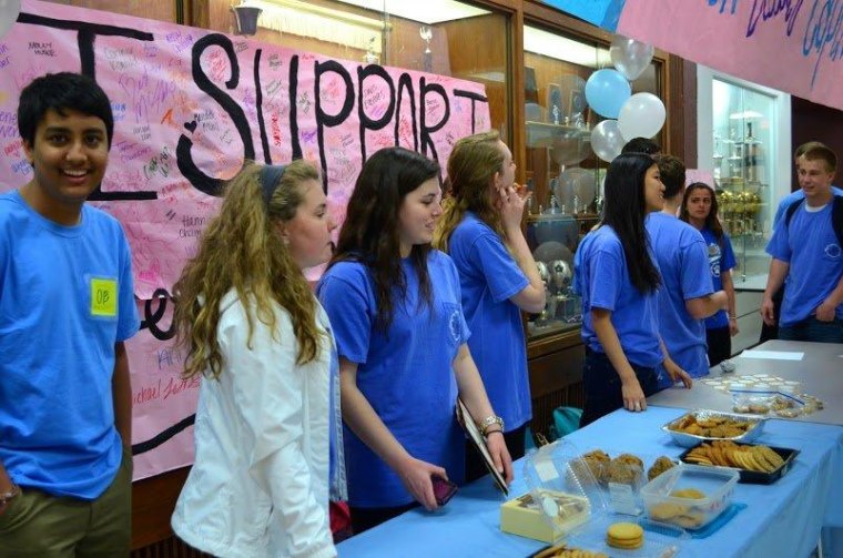 Students pass out cookies to raise awareness of the makeup-free school day.