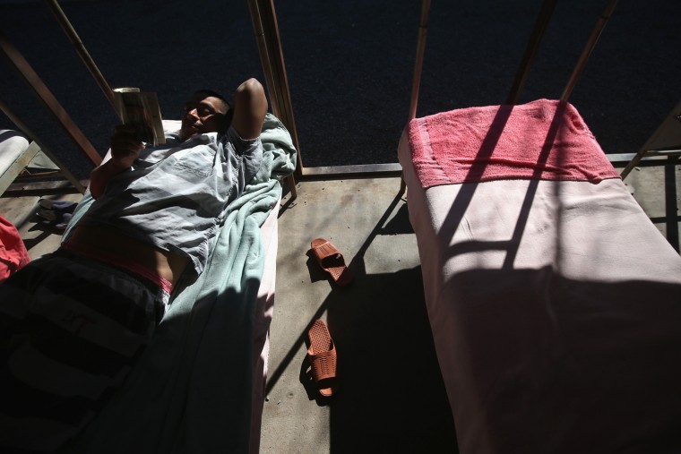 An immigrant inmate reads on his bunk at the Maricopa County Tent City jail on March 11, 2013 in Phoenix, Arizona.