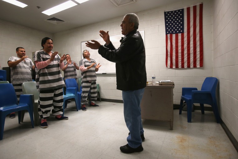 A minister leads immigrant inmates during a Protestant church service at the Maricopa County Tent City jail.