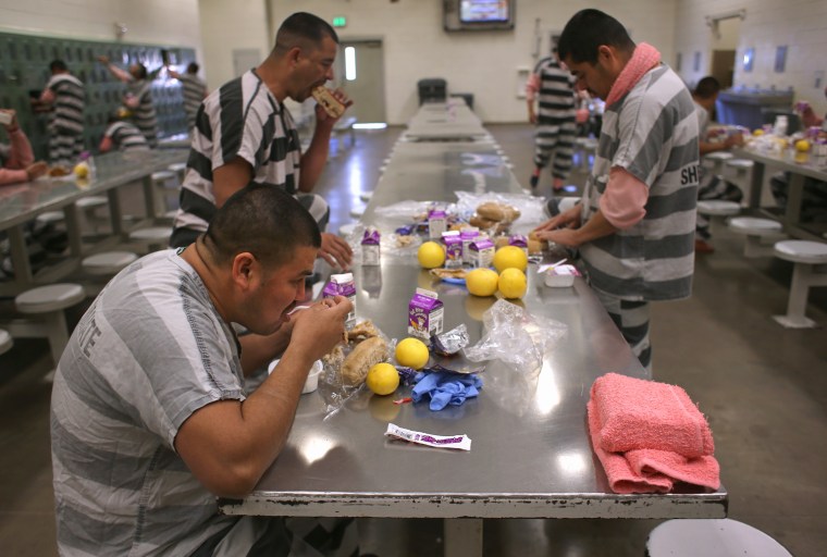 Immigrant inmates eat breakfast at the Maricopa County Tent City jail.