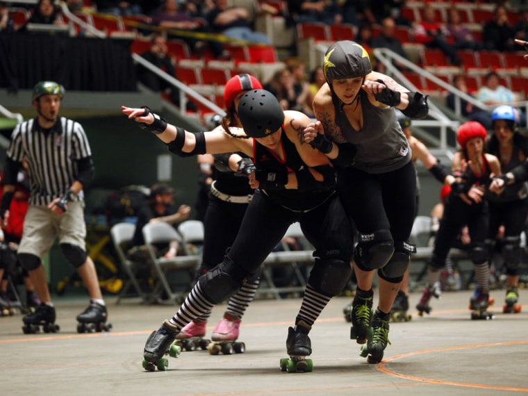 Members of the Detroit Derby Girls Travel Team battle The Chicago Outfit Syndicate during a women's flat track roller derby bout in Detroit, Michigan, in April 2011.