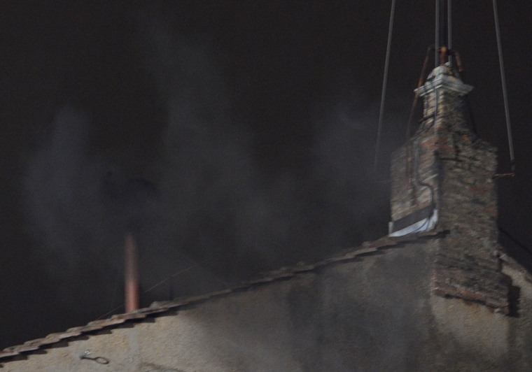 Black smoke rises from the chimney on the roof of the Sistine Chapel on Tuesday.