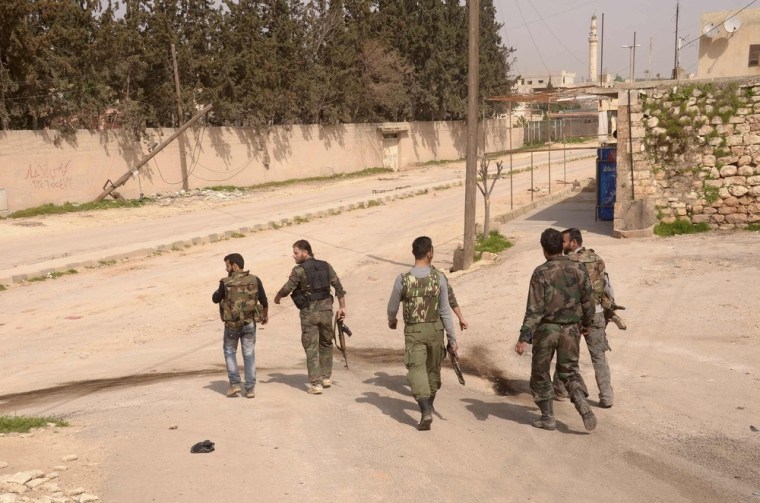 Soldiers loyal to Syria's President Bashar al-Assad walk through Khan al-Assal area, near Aleppo city on Tuesday, Mar. 12.