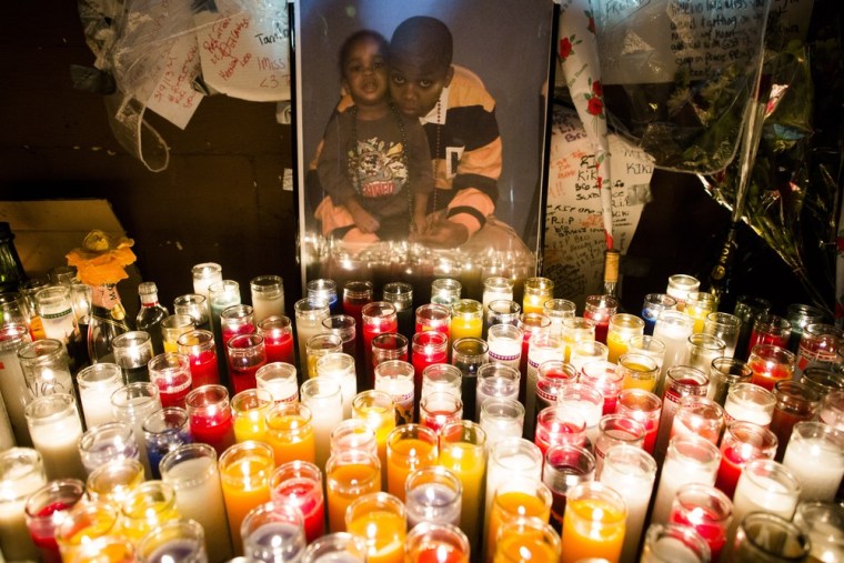 Memorial candles stand beside a picture of Kimani Gray during a vigil for the deceased teen on March 13, 2013.