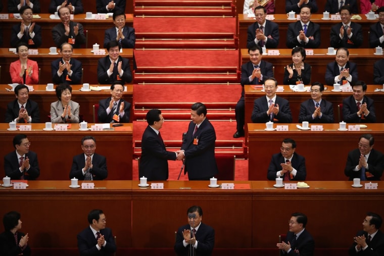China's newly-elected President Xi Jinping, right, shakes hands with former President Hu Jintao, left, as other delegates clap during the fourth plenary meeting of the National People's Congress at the Great Hall of the People on March 14, 2013 in Beijing.