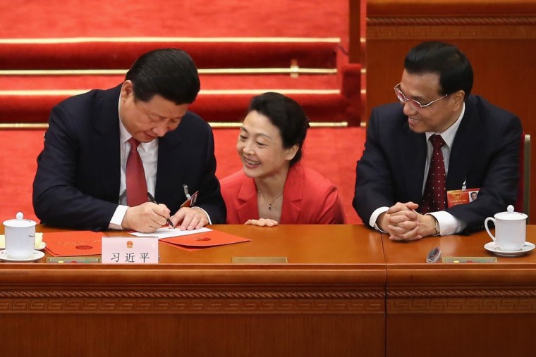 A delegate gets the newly-elected Chinese President Xi Jinping, left, and incoming Premier Li Keqiang, right, to sign autographs after the election of the new president on March 14, 2013 in Beijing.