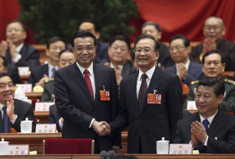 China's newly-elected Premier Li Keqiang (left) shakes hands with former Premier Wen Jiabao as China's President Xi Jinping, seated right, and other delegates applaud Friday. Li was once friends with democracy activists, but a dissident accused him of covering up an HIV scandal.