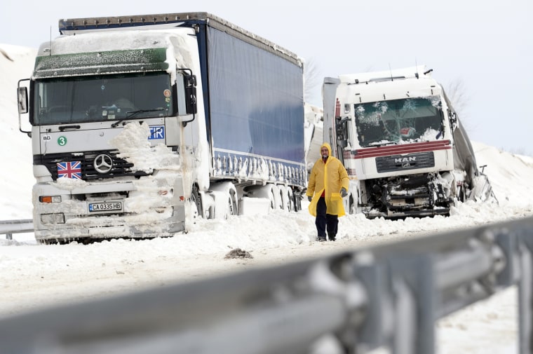 A man walks past a damaged truck at the site of an accident on the E71 motorway, near the Croatian, Slovenian and Hungarian borders on Friday, a day after a heavy snow storm hit the area.