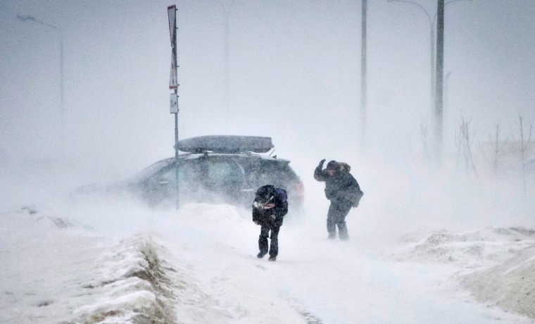 People struggle against wind and drifting snow in the Belarus capital, Minsk, on Friday.
