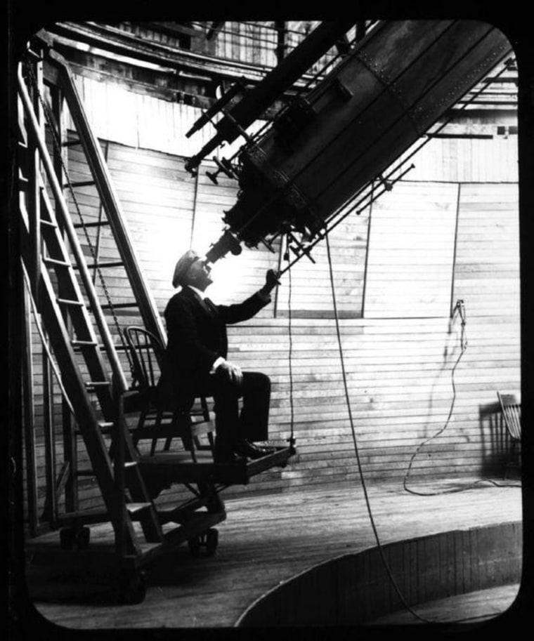 In this undated historical file photo, Percival Lowell looks through the Clark Telescope at the Lowell Observatory in Flagstaff