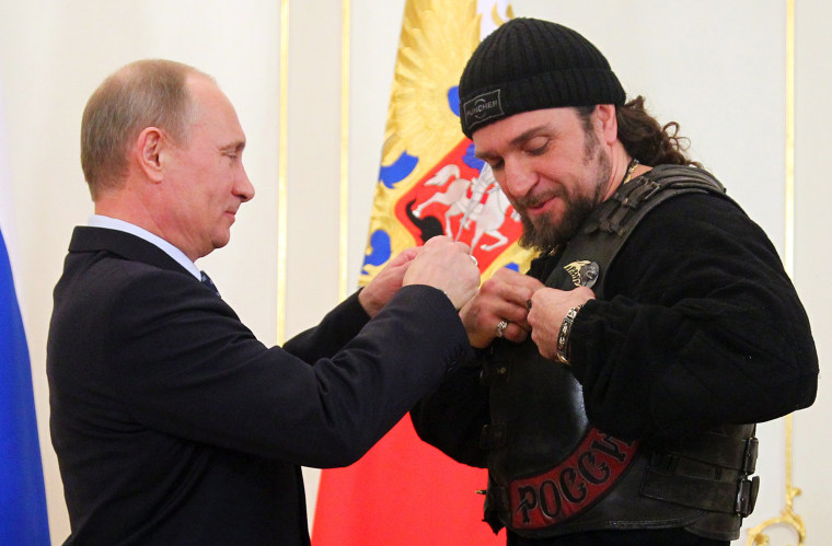 Russia's President Vladimir Putin hands a medal to the leader of Nochniye Volki (the Night Wolves) biker group, Alexander Zaldostanov, also known as Khirurg (the Surgeon).