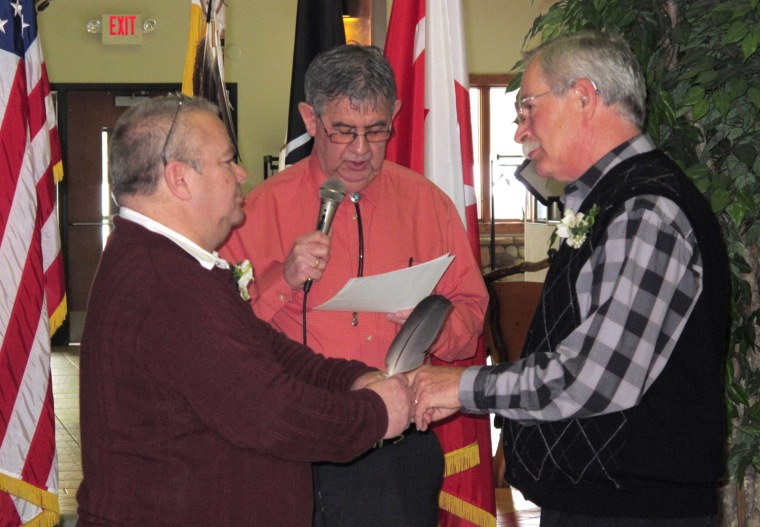 Tim LaCroix, left, and Gene Barfield recite their nuptial vows in the governmental building of the Little Traverse Bay Bands of Odawa Indians, Friday, March 15, 2013, in Harbor Springs, Mich. Tribal Chairman Dexter McNamara, center, officiated during the wedding after signing a measure approved by the tribal council that allows same-sex marriages on the reservation.