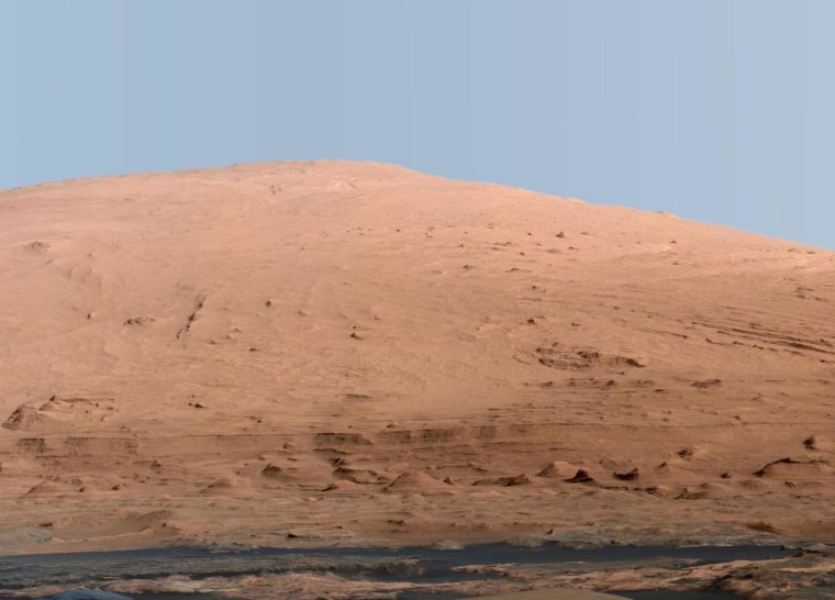 This mosaic of images from the Mast Camera (Mastcam) on NASA's Mars rover Curiosity shows Mount Sharp, also known as Aeolis Mons, in a white-balanced color adjustment that makes the sky look overly blue but shows the terrain as if under Earthlike lighting. This is just a small segment of a wider panorama assembled from image data collected on Sept. 20, 2012. The sky has been filled out by extrapolating color and brightness information from the portions of the sky that were captured in images of the terrain. A raw-color version of the mosaic shows the scene's colors as they would look in a typical smartphone camera photo taken on Mars. Click on the image to see a larger version from NASA.