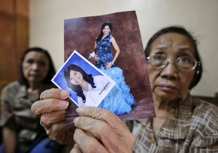 Pilar Pangalinan, 75, holds pictures of her late granddaughter Kristel Tejada during a wake in Manila on March 18.