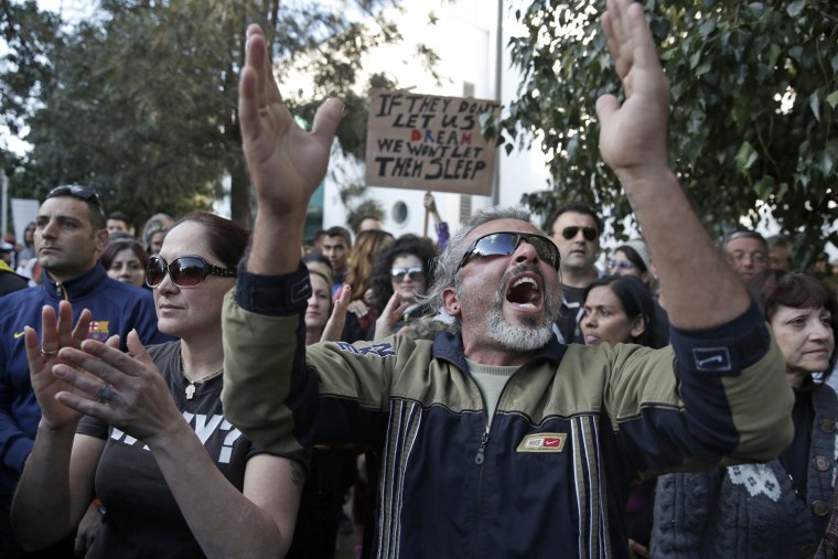 Protesters shout slogans during an anti-bailout rally outside the parliament in Nicosia on March 18, 2013.
