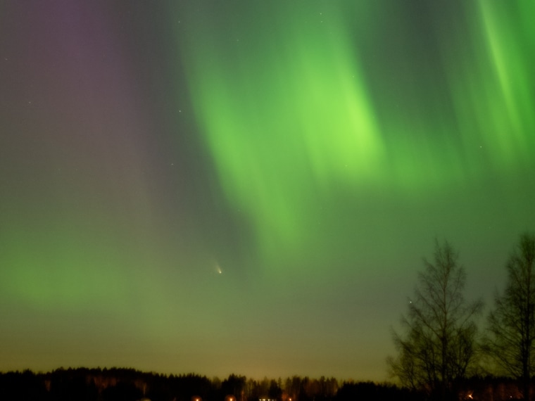 Comet PanSTARRS twinkles amid the glow of the northern lights over Lempaala in central Finland on March 17.