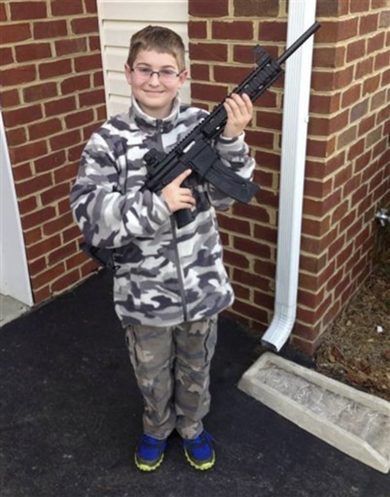 This undated photo provided by Shawn Moore shows his son Josh, 10, holding a rifle his father gave him for his 11th birthday, at their home in Carneys Point, N.J.