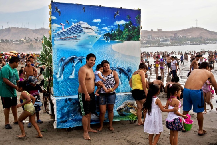 Karina Alvarado and David Enriquez pose for a picture with their daughter at Agua Dulce beach. For five Peruvian soles or about two U.S. dollars beach goers can pose for a photo in front of backdrops of their choice that include forest landscapes, exotic beach scenes or atop horses.