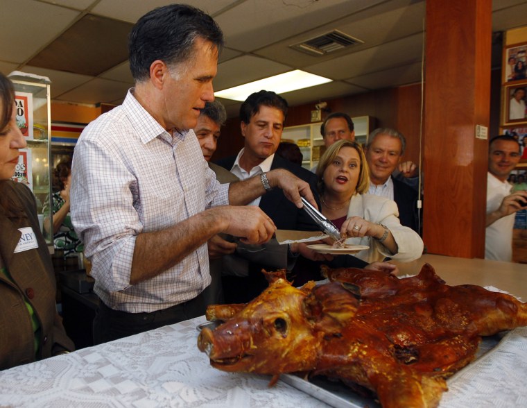 Mitt Romney cuts and serves a roast pig during a campaign stop at Casa Marin restaurant in Hialeah, Florida.