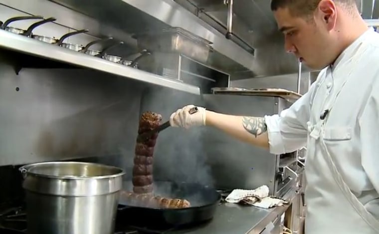 A cook prepares the Wagyu beef for the main course.