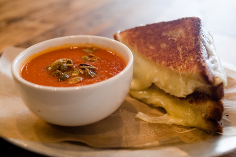 Cheddar and mozzarella on brioche, with house-made tomato soup and curried pumpkin seeds from Queens Kickshaw in New York.