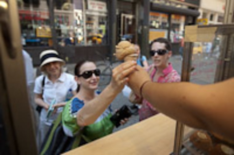 A customer orders an ice cream cone from a Van Leeuwen gourmet food truck.