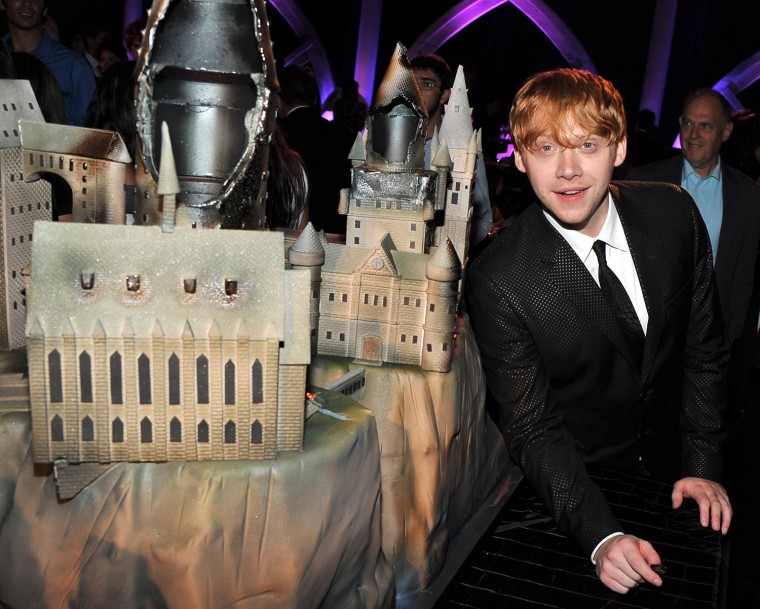 Rupert Grint poses with Charm City's cake creations, at the American Museum of Natural History in New York City.