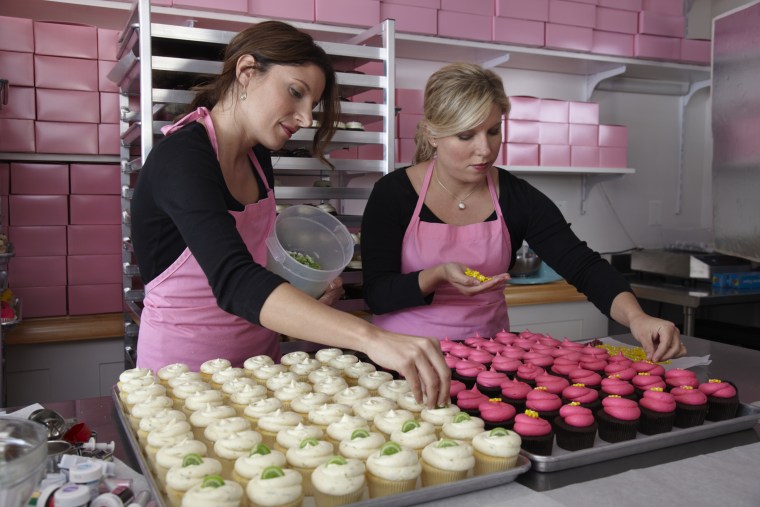 From left, sisters Katherine Kallinis and Sophie LaMontagne craft cupcakes at their bakery in the Georgetown district of Washington, D.C.
