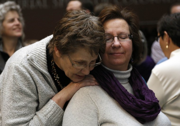 Shawn Walter (L) and wife Hillary Gilfand embrace after Colorado Governor John Hickenlooper signed into law the civil unions act in Denver March 21, 2013.