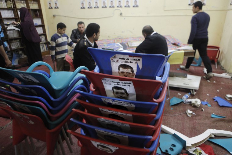 Egyptian policemen write a report at a destroyed branch headquarters of the Muslim Brotherhood after protesters broke in to the building in Cairo, Egypt, on March 22, 2013.