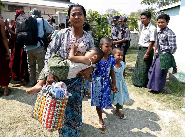 People carry their belongings as they arrive at a temporary rescue center in Meikhtila on March 22, 2013.