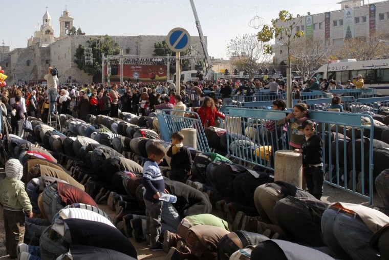 Palestinian Muslims take part in Friday noon prayers in Manger Square, outside the Church of Nativity, traditionally believed by Christians to be the birthplace of Jesus.