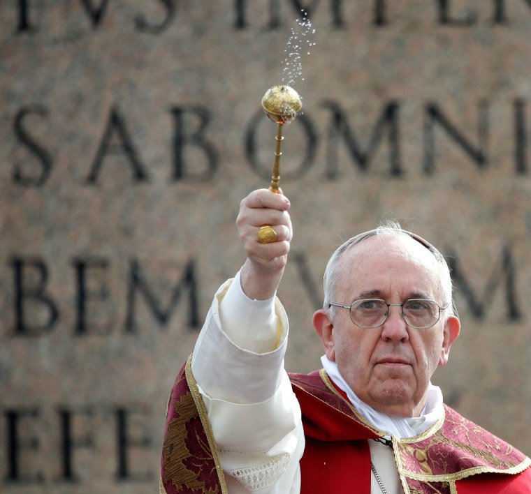 Pope Francis uses an aspergillum to sprinkle holy water as a blessing.