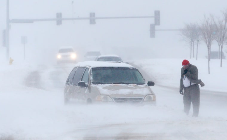 A man waits for help after becoming stuck in snow along West 6th Street in Lawrence, Kan., March 24.