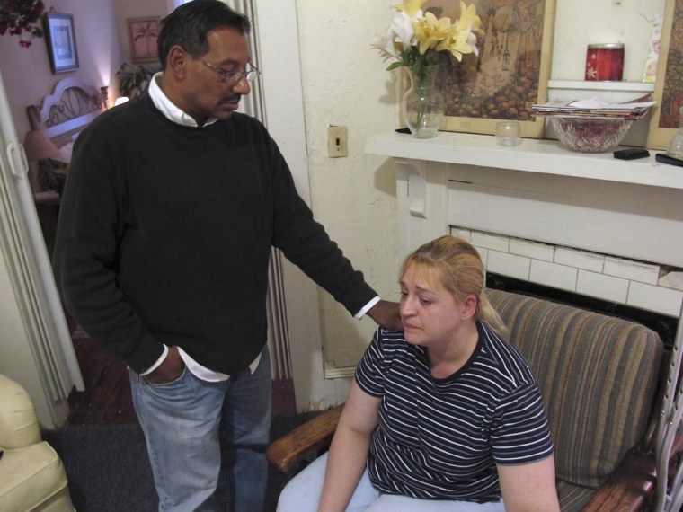 Luis Santiago tries to comfort Sherry West at her apartment Friday, March 22, 2013, in Brunswick, Ga., the day after their 13-month-old son, Antonio Santiago, was shot and killed. West says she was walking her baby in his stroller when a teenage gunman demanding money shot the baby in the face and shot her in the leg. (AP Photo/Russ Bynum)