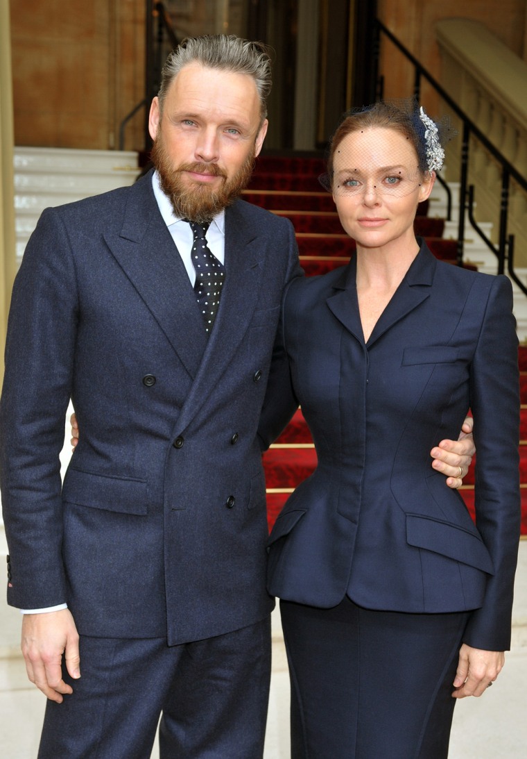 Alasdhair Willis with his wife Stella McCartney pose at Buckingham Palace.