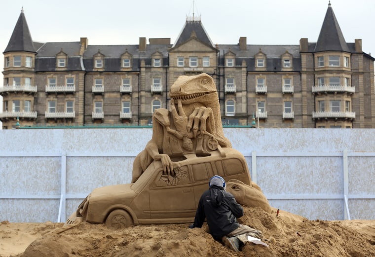 A sand sculptor works on a