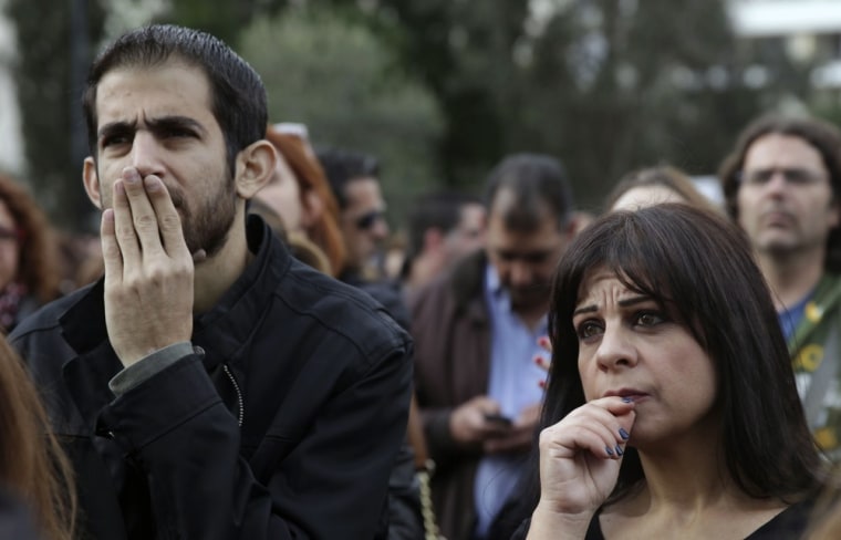 Employees of the Bank of Cyprus frown as they demonstrate outside the main office of the bank in Nicosia on Tuesday.
