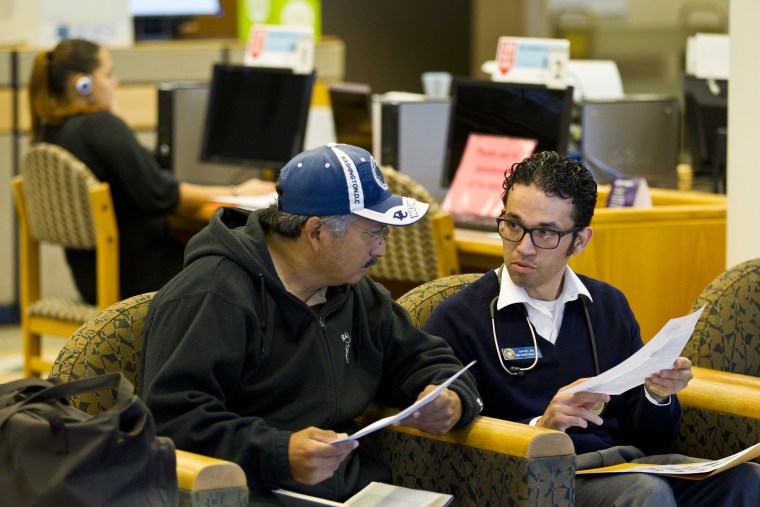 Nurse Daniel Lopez gives Henry Cardoza information on local shelters at the Joel D. Valdez Main Library in Tucson, Ariz.