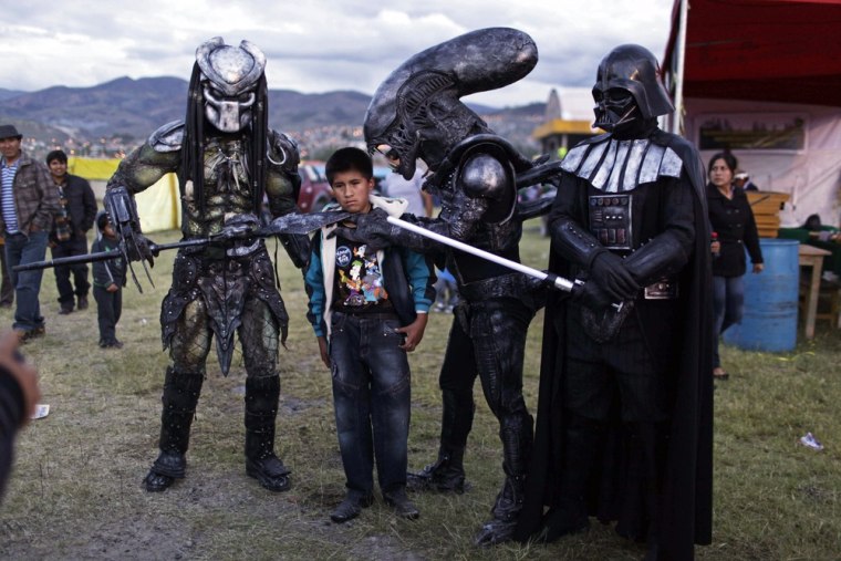 A boy poses for a picture with people wearing costumes of famous sci-fi movie characters during the Canaan fair, which is part of the Holy Week events in Ayacucho, Peru, on March 28, 2013. Catholics around the world commemorate Jesus' crucifixion on Good Friday before celebrating his resurrection on Easter Sunday.
