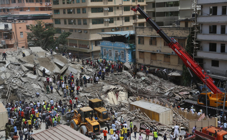 An aerial view shows bystanders watching rescuers search for survivors in the rubble of a collapsed building in Tanzania's commercial capital on Friday.