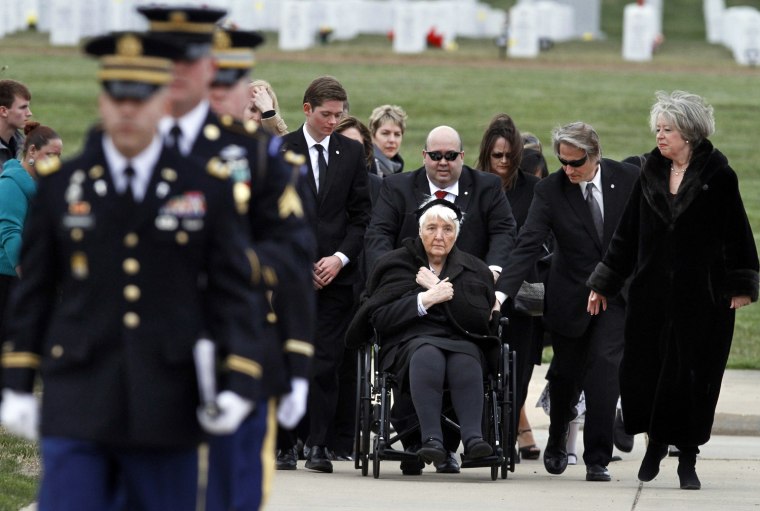 The family of Dr. Rene Joyeuse attend his burial service at Arlington National Cemetery in Arlington, Va., March 29. In the wheelchair is Joyeuse' widow, Suzanne Joyeuse, with their son's Marc Joyeuse, and Remi Joyeuse, right.