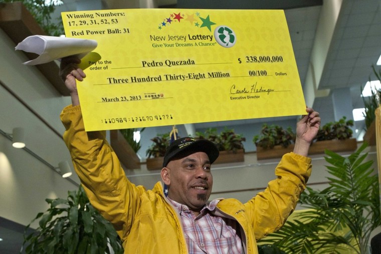 Pedro Quezada holds up the promotional Powerball jackpot check of $338 million at the end of a news conference at the New Jersey Lottery headquarters in Trenton, March 26, 2013.
