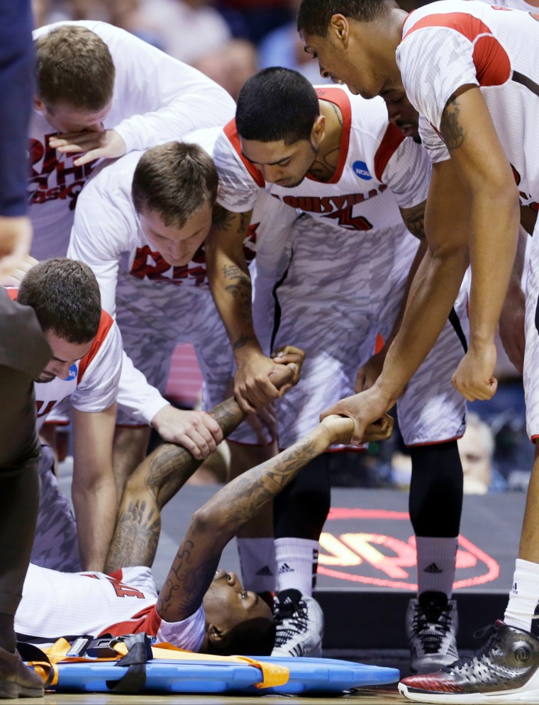 Louisville players talk to guard Kevin Ware after Ware's injury during the first half of the Midwest Regional Final against Duke in the NCAA basketball tournament March 31 in Indianapolis, Ind.
