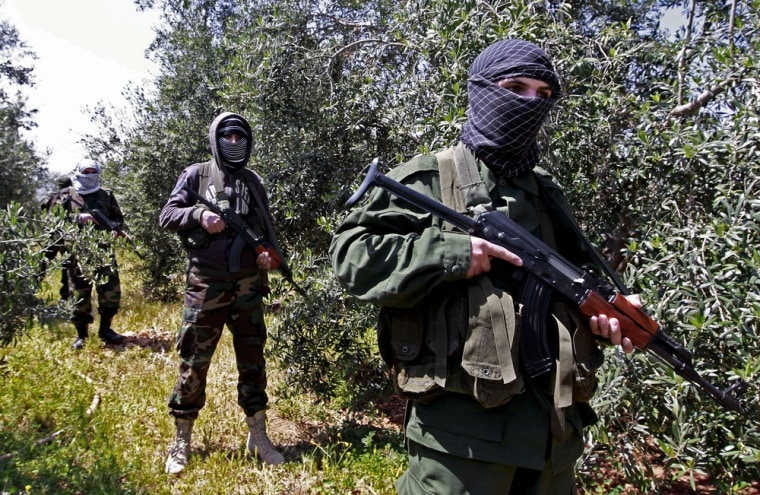 Pro-Syrian-government fighters from Lebanon stand guard at the border of the two countries on April 12. The head of Lebanon-based Hezbollah has threatened that his heavily armed group, backed by Iran, may become further involved in the battle against forces trying to topple Syrian President Bashar Assad.