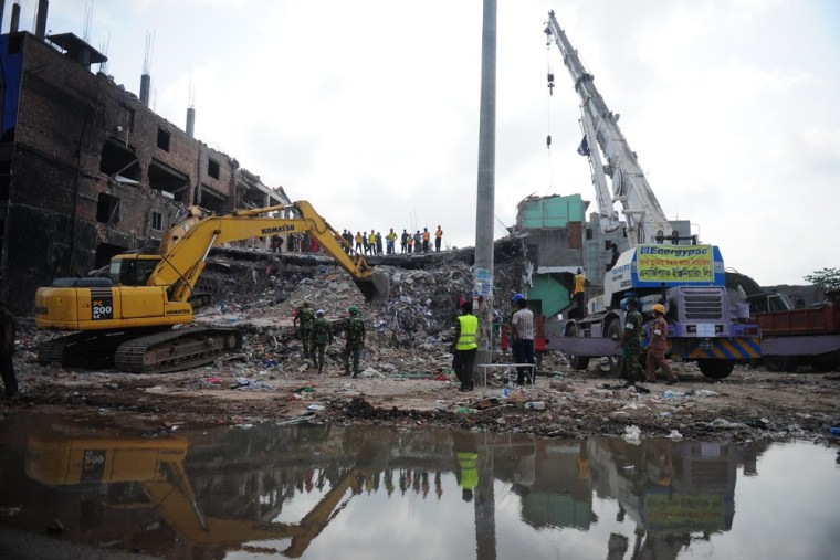 Bangladeshi rescuers use a digger to move debris as Bangladeshi Army personel continue the second phase of a rescue operation using heavy equipment af...